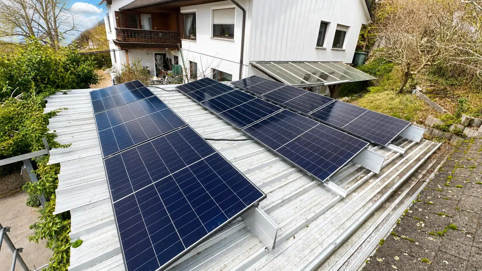Montierte Doppelglas PV-Module auf einem Dach in Ansbach mit Hybrid-Wechselrichter, Heimspeicher und Hems im Keller als auch einer Wallbox in der Garage.