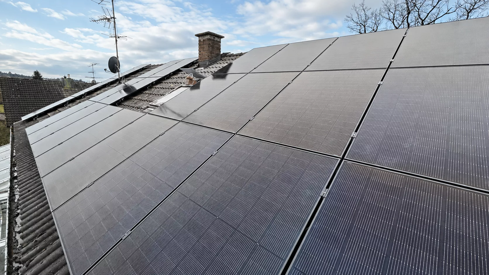 Montierte Full-Black PV-Module auf einem Dach in Burglengenfeld mit Hybrid-Wechselrichter, Heimspeicher, Wärmepumpen-Ansteuerung und Hems im Keller.