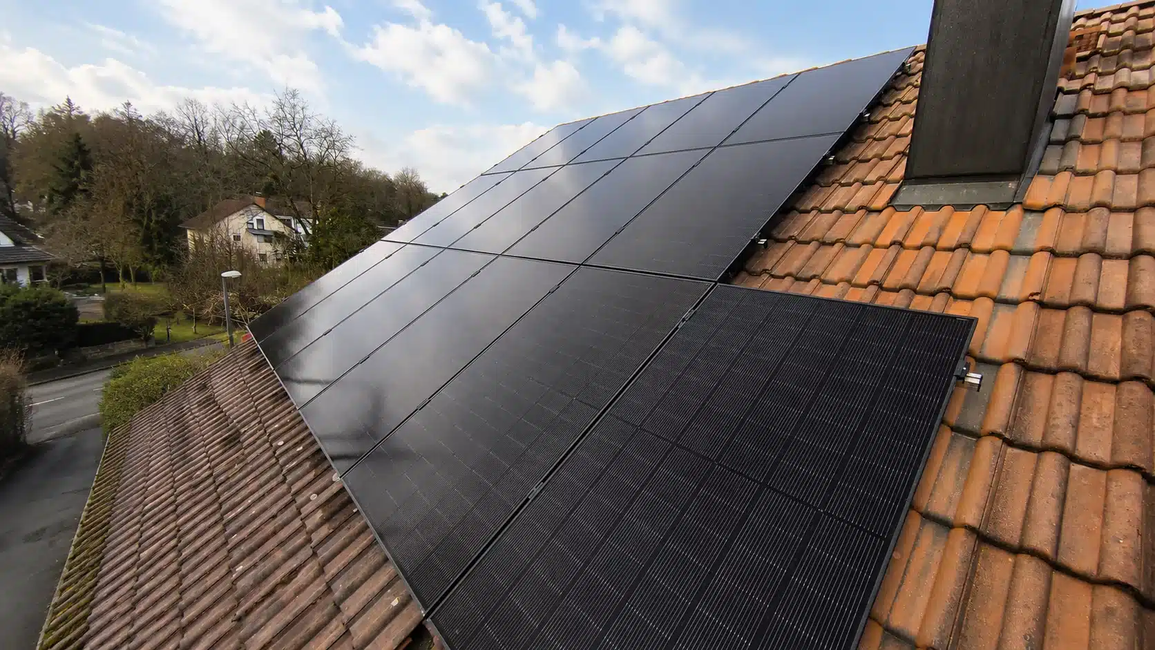 Montierte Full-Black PV-Module auf einem Dach in Landshut mit Hybrid-Wechselrichter, Heimspeicher und Hems im Keller.
