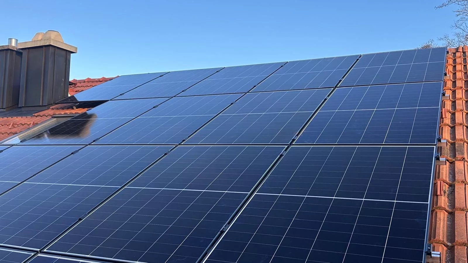 Montierte Doppelglas PV-Module auf einem Dach in Otterfing mit Hybrid-Wechselrichter, Heimspeicher, Wärmepumpenansteuerung und Hems im Keller.