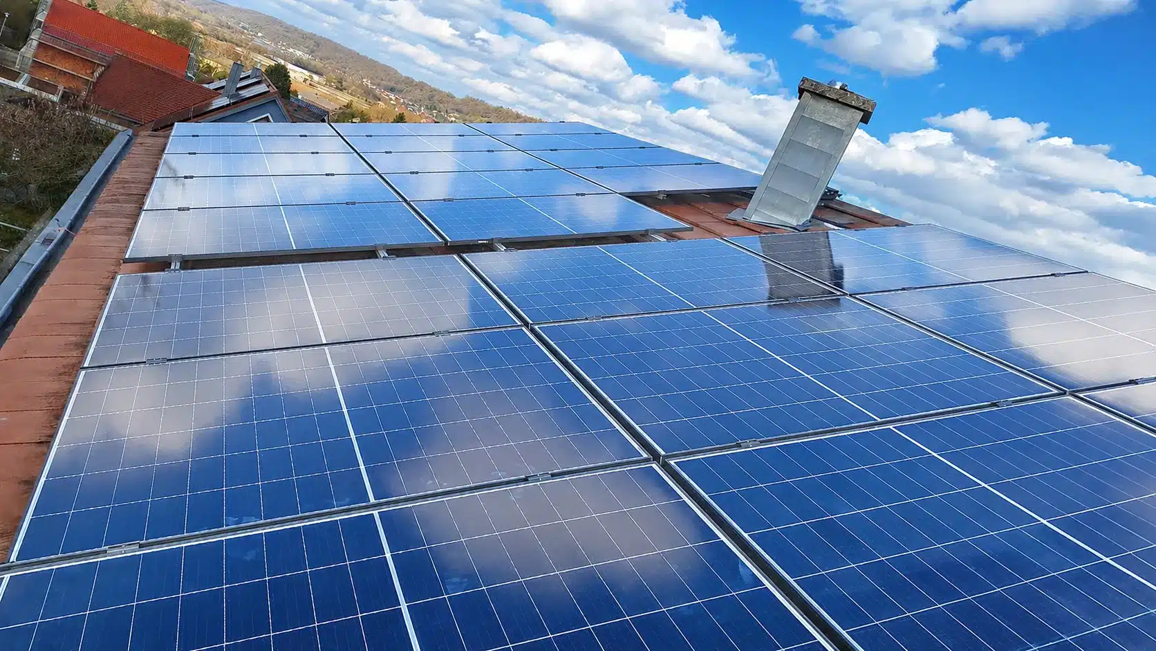 Montierte Doppelglas PV-Module auf einem Dach in Pettendorf in Full-Black-Optik mit Hybrid-Wechselrichter, Heimspeicher, Erstatzstrombox, Heizstabansteuerung und Hems im Keller.